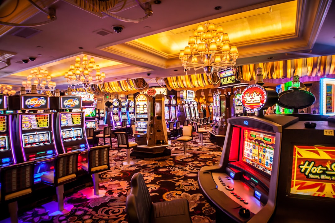 Interior of a casino with brightly lit slot machines and decorative chandeliers